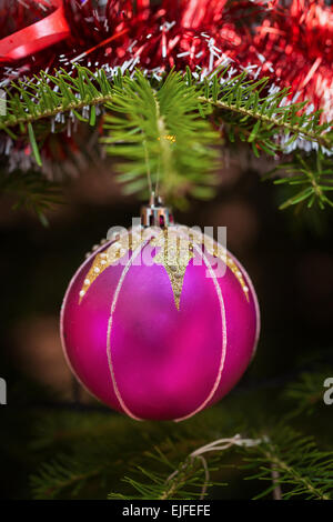 Rosa Weihnachtskugeln im Freien auf einem Baum Stockfoto