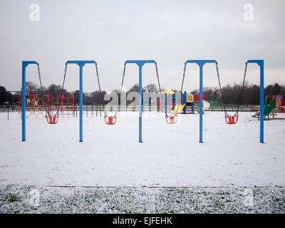 Schaukeln in einer leeren Kinder Spielplatz mit Schnee bedeckt Stockfoto
