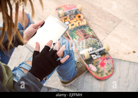 Abgeschnitten Bild männlichen Freiberufler mit Dreadlocks sitzen mit digital-Tablette eingeben warm Nachrichtenfilter angewendet Stockfoto