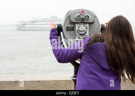 Frau mit dem Fernglas bei Upper New York Bay, Ellis Island, Jersey City, New York State, USA Stockfoto