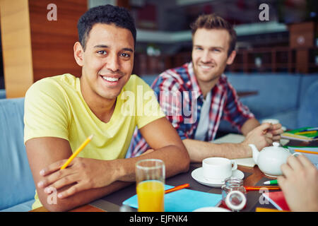 Zwei jungen beim Frühstück sitzen und Blick in die Kamera Stockfoto