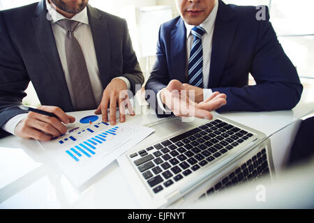 Zwei Männer in Anzügen, die auf der Suche nach Entscheidung in Finanzfragen Stockfoto