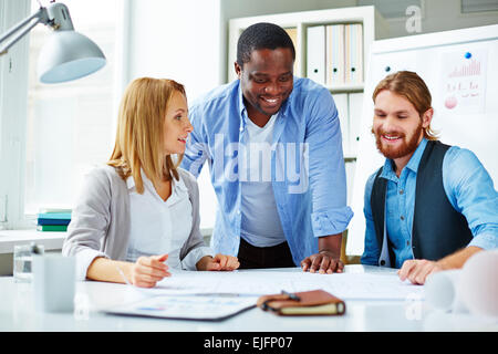 Drei Geschäftsleute Planung über Entwurf Stockfoto