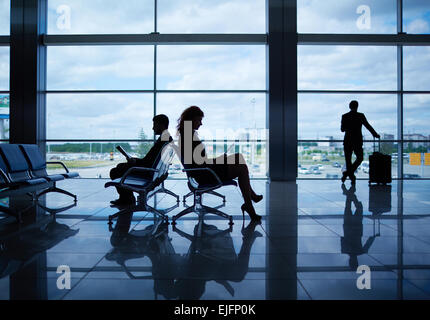 Gliederung der Geschäftsleute in Abflughalle lesen Stockfoto