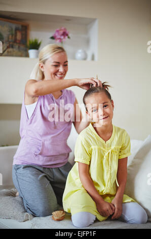 Die Frisur für ihre Tochter Mutter Stockfoto