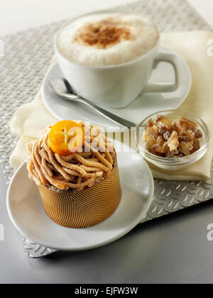 Kuchen mit einem trippelte Schokolade Gehäuse und Pipe Kastanienpüree mit Kumquat-Sauce, in einem modernen Designer-Teller Stockfoto