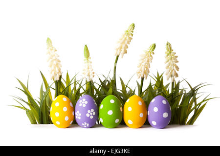 Ostereier mit Blume auf frischen grünen Rasen auf weißem Hintergrund Stockfoto