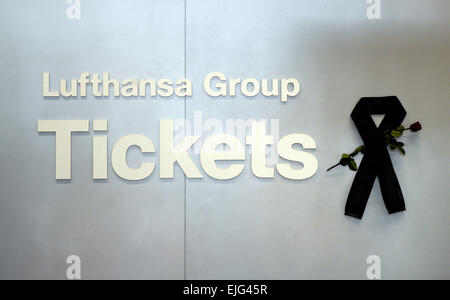 Düsseldorf, Deutschland. 26. März 2015. Ein schwarzes Band und eine rose hängen durch das Zeichen für die Lufthansa Ticketschalter am Flughafen in Düsseldorf, 26. März 2015. Am 24. März 2015 stürzte ein Germanwings Aribus A320 in den französischen Alpen. Foto: CAROLINE SEIDEL/Dpa/Alamy Live News Stockfoto