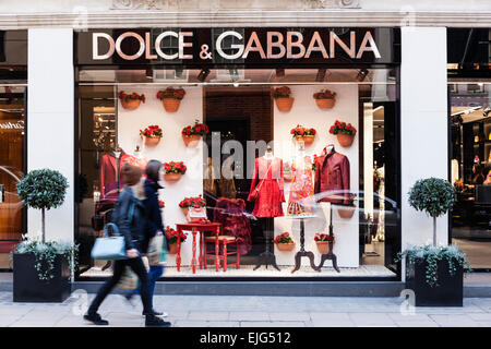 Ein paar junge Frauen gehen durch die & Gabbana Dolce-Fashion-Store auf Old Bond Street, Mayfair, London, England. Stockfoto