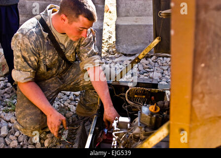 Provinz LOGAR, Afghanistan – US-Armee CPL. Mitchell A. Weaver, Williamsport, MD., Native und ein Radfahrzeug Mechaniker zugewiesen Firma F, 2. Bataillon, 30. Infanterie-Regiment Task Force Sturm, behebt Lal-Mohammad-Trabi drei Kilowatt Generator am Baraki Barak in der Provinz Logar 18 November.  US-Armee CPL. Cooper T. Cash, 210. Mobile Public Affairs Abteilung, Task Force Patriot Read full Story hier: www.dvidshub.net/news/60665/us-army-mechanic-assures-afgh... www.dvidshub.net/news/60665/us-army-mechanic-assures-afghans-retain-power-information Stockfoto