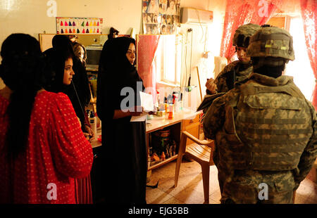 US Army 1st Lt. Julie Leggett, Executive Officer für die 25. spezielle Truppen Bataillon Sicherheitsabteilung, 25. Infanterie-Division, Gespräche mit einem lokalen Beauty-Shop-Besitzer ihr beurteilen muss, ihre geschäftliche Produktivität, in Al Sequor, Irak, 12. August 2009 zu verbessern.   Staff Sgt Luke P. Thelen Stockfoto