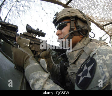 US Army Staff Sgt. Paul Ythemar zieht hinten Sicherheit in der hinteren Luke ein Stryker Sturmfahrzeug während auf dem Weg zum nächsten Ziel seiner Clearing-Mission in Bagdad, Irak, 4. Mai 2007. Ythemar ist die 3. Stryker Brigade Combat Team, 2nd Infantry Division zugeordnet.  Techn. Sgt Cecilio M. Ricardo Jr. Stockfoto