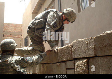 US Armee Sgt. Jesse McDowell klettert über eine Mauer während einer Aufklärungs-Operation zu einen möglichen Aufständischen Raketenwerfer im Bereich Al Dora von Bagdad, Irak, 25. Mai 2007 erholen. McDowell ist von Alpha Company, 2. Bataillon, 12. Infanterie-Regiment, 2nd Infantry Brigade Combat Team, 2. US-Infanteriedivision.  Staff Sgt Bronco Suzuki Stockfoto