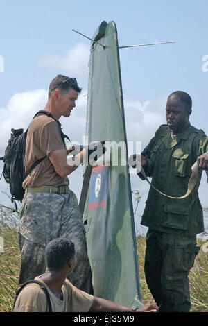 US Armee Sgt. 1. Klasse Mike Parks, 1. Bataillon, 228th Aviation Regiment Qualitätskontrolle Unteroffizier verantwortlich und ein Soldat aus der Belize Defence Force Ladung Gurt das Ruder ein abgestürztes Flugzeug der BDF Verteidiger in Belize 3. Mai 2007. Die abgestürzten BDF Verteidiger werden Slingloaded auf eine US-Army UH-60 Black Hawk-Hubschrauber und Auslieferung auf der BDF-Air-Station am Flughafen von Belize City.  Staff Sgt Chyenne A. Griffin Stockfoto