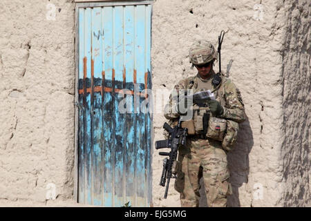 US Armee Sgt. Keith Keller, ein Kampfingenieur zugewiesen 3rd Platoon, Alpha Company, 3. spezielle Truppen Bataillon, 3. Brigade Combat Team "Rakkasans", 101st Airborne Division Air Assault Task Force 3/101, berät eine Karte, um die beste Route zum nächsten Ziel zu bestimmen, während einer Patrouille durch ein Dorf in Khowst Provinz, Afghanistan, 12. Januar 2013. 3. Zug war die Durchführung einer Volkszählung von der Dorfbevölkerung, inklusive Anzahl der Personen im Haushalt, Beruf und Länge der Zeit leben in der Residenz.  Sgt. Kimberly Trumbull Stockfoto