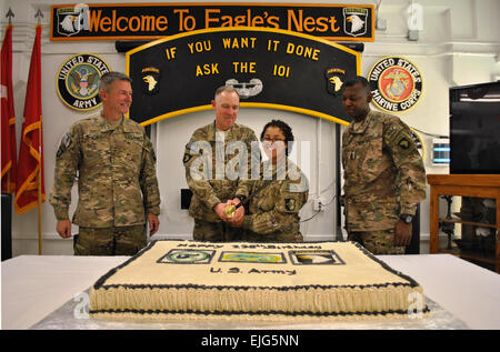 US-Armee Generalmajor James C. McConville links, Kommandierender general, kombiniert Joint Task Force - 101 und Regional Command East und Eingeborener von Quincy, Massachusetts, und US Armee Command Sergeant Major Alonzo J. Smith rechts, Befehl Sergeant-Major, CJTF - 101 und RC-Ost und gebürtig aus Fayetteville, NC, Blick auf als US Armee Sgt. Major Thomas Coulter, CJTF - 101 und RC-Ost CJ2 Intelligenz-Sergeant-major , und US Armee Pvt. Alice Harris, CJTF - 101 und RC-Ost CJ1 Personal Auszeichnungen Schreiber, Vorbereiten der feierliche erste Spatenstich in einen Geburtstagskuchen machen 238. Geburtstag der US-Armee in Bagram Airfiel Stockfoto