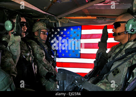 US Army Chief Warrant Officer Rick Tyson schwört in Spc. Rodger Beko während eine Neueintragung in einem Black Hawk Hubschrauber schwebt über der Stadt Kandahar, Afghanistan, 7. März 2012. Tyson ist die Brigade alle Quelle Geheimdienstchef. Beko, ein intelligenter Analytiker mit 1. Geschwader der 4. Infanterie-Division, 10. Kavallerie-Regiment, 2nd Brigade Combat Team, neu angeworben, um weitere drei Jahre zu dienen.  Sgt. Ruth Pagan Stockfoto