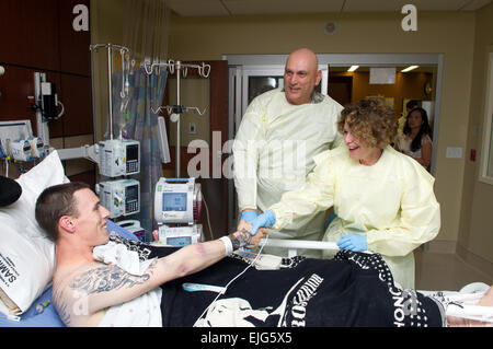 Linda Odierno und Army Chief Of Staff General Ray Odierno, Grüße Armee Spc. Zac Gore während eines Besuchs in Brooke Army Medical Center in Joint Base San Antonio - Fort Sam Houston, Texas, 16. April 2013. Gore verlor seinen linken Arm und Bein, als er auf eine hausgemachte Bombe während des Dienstes in Afghanistan trat.  Staff Sgt Teddy Wade Stockfoto