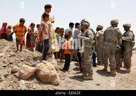 US-Armeesoldaten sprechen mit den Irakern und ohnmächtig Autoaufkleber mit lokalen Notfall Kontaktinformationen in Basra, Irak, 21. Juli 2009. Die Soldaten sind die 445th Civil Affairs Bataillon zugeordnet.  SPC. Samantha R. Ciaramitaro Stockfoto