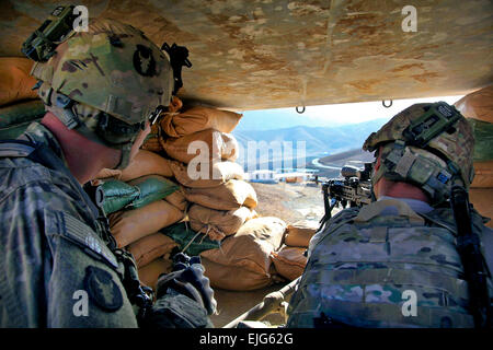 US Army Staff Sgt. Paul Deugan links Ankeny, Iowa und Sgt. Drew Russell direkt von Dubuque, Iowa beide Kavallerie mit Bravo Truppe Pfadfinder, 1. Staffel, 113 Kavallerie-Regiment Scannen ihres Sektors des Feuers während Russell ein M249 Squad automatische Waffe sah am Fahrzeug Patrol Base Dandarh, nutzt Parwan Provinz, Afghanistan, 1. Januar 2011. Bravo besucht Truppe Fahrzeug Patrol Base Dandarh, der Basisverteidigung aufzubauen und durchzuführen abgesessene Patrouillen durch die umliegenden Dörfer um Sicherheit zu gewährleisten.  SPC. Kristina Gupton Stockfoto