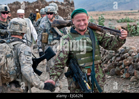 Nach der Entdeckung ein Waffenlager in Dag Mene, einem Dorf im Osten Afghanistans Provinz Kunar, ein Afghan National Army Soldat Lächeln und schüttelt Hände mit US Army Spc. Joshua D. Heinbuch, Infanterist aus Englewood, Florida, zugewiesenen Unternehmen C, 2nd Battalion, 327th Infanterie-Regiment, Task Force No Slack November 4.  US Army Staff Sgt Mark Burrell, 210. Mobile Public-Affairs-Abteilung Stockfoto