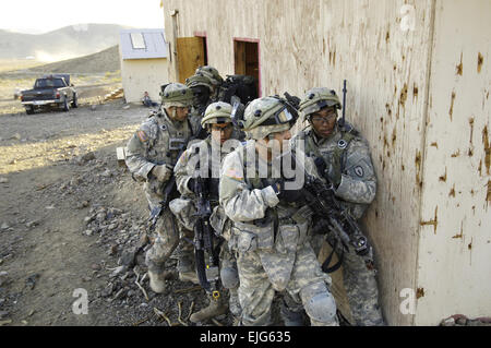 US-Armeesoldaten aus der 25. Infanterie-Division aus Schofield Barracks, Hawaii, stapeln sich außerhalb eines Gebäudes während einer Ausbildung Bewegung in Fort Irwin, Kalifornien, 25. September 2007. Die Soldaten sind Training für den bevorstehenden Einsatz in den Irak.  SPC. Tiffany Dusterhoft Stockfoto