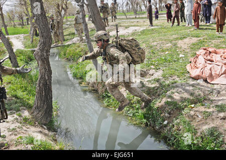 US Army Staff Sgt Andy Short, Führer einer Einheit zugeordnet, 1. Bataillon, 501. Infanterie-Regiment, Task Force Blue Geronimo, springt über einen Bewässerungskanal in der Nähe des Dorfes Gorchek, Khost Provinz, Afghanistan, während der Operation Naruz oder Silvester am 30. März 2012.   Staff Sgt Jason Epperson, US-Armee.  Veröffentlicht Stockfoto