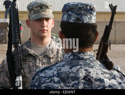 SPC. Lucas Sweeney verließ, Stromschnellen, Wisconsin, USA, 1. Kavallerie-Division-Ehrengarde, Multi-National Division – Bagdad, führt Bohrer mit Matham Hussein Ali, 1. Bundesliga, am 8. Februar Camp Liberty. Die zwei Praxis-Gewehr-Bewegungen in Vorbereitung auf die kommende MND-B-Übertragung der Behörde Zeremonie, in der das 1. Cav. Div. Verantwortung für das operative Umfeld von Bagdad aus der 4. Infanterie-div übernimmt. Stockfoto