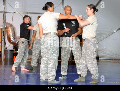 Staff Sgt Kevin Wright, Center, unbewaffnete Selbstverteidigung Kursleiter erklärt eine unbewaffnete Selbstverteidigung-Technik 1. Lt. Sovannchampa Touch, links, und 1st Lt. Erin Kan, Mitgliedern des 724. Militärpolizei Bataillons. Unbewaffnete Selbstverteidigung ist erforderlich für Einheiten, die Vorbereitung zur Durchführung Häftling Operationen zur Unterstützung der Overseas Contingency Operations training. Division West, erste United States Army hat die Verantwortung für die Ausbildung aller Bereitstellung von Nationalgarde und Reserveeinheiten Häftling Operationen durchführen. US Army CPT John Brimley Stockfoto