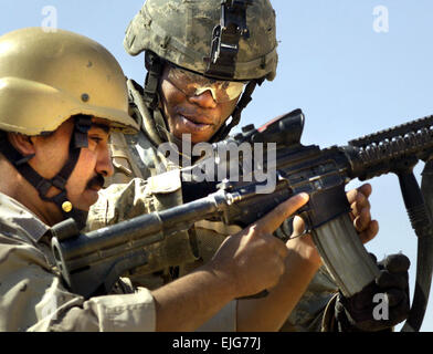 Staff Sgt Jesse Linen, 1. Brigade Combat Team, 1. US-Panzerdivision, zeigt ein Mitglied der irakischen Armee die Funktionen der m-4-Sturmgewehr während gemeinsame Waffentraining in Tal Afar, Irak am 18. Mai 2006.  Das Ziel des Trainings war zweifach, so dass amerikanische und irakische Kräfte gegenseitig auf verschiedenen Waffensystemen vertraut zu machen und die Entwicklung von Esprit de Corps unter beide Armeen.  Staff Sgt Jacob N. Bailey.      . Stockfoto