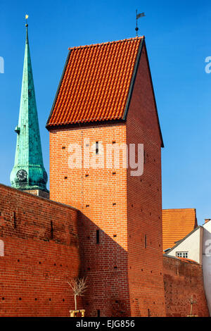 Rote Festungsmauer und einen Turm mit einem Hahn in Riga gegen den blauen Sommerhimmel. Lettland Stockfoto