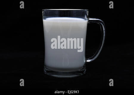 Ein Bierkrug ist gefüllt mit Milch auf schwarzem Hintergrund isoliert Stockfoto