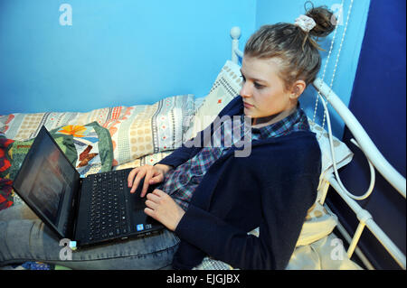 Eine Teenager-Mädchen nutzt ihr Laptop in ihrem Schlafzimmer. MODEL RELEASED Stockfoto