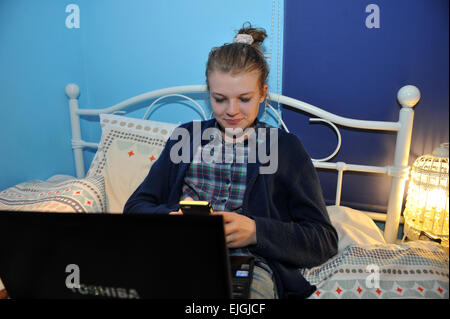 Eine Teenager-Mädchen nutzt ihr Laptop in ihrem Schlafzimmer. MODEL RELEASED Stockfoto