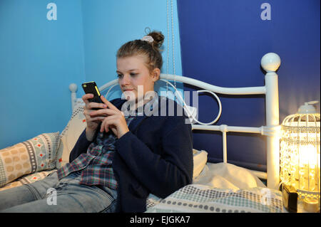 Eine Teenager-Mädchen nutzt ihr Laptop in ihrem Schlafzimmer. MODEL RELEASED Stockfoto