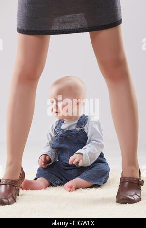 Baby zwischen die Beine der Mutter Stockfoto