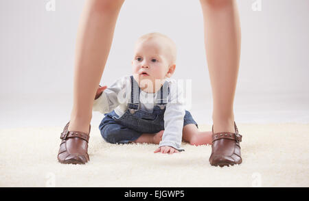 Baby zwischen die Beine der Mutter Stockfoto