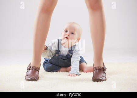 Baby zwischen die Beine der Mutter Stockfoto