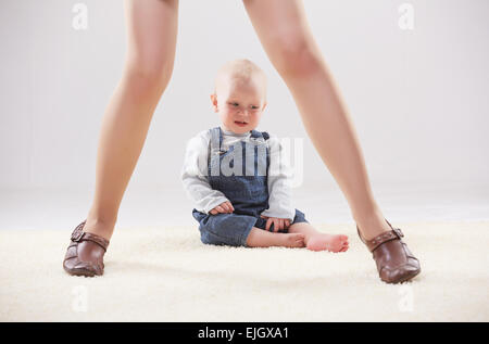 Baby zwischen die Beine der Mutter Stockfoto