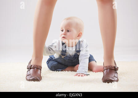 Baby zwischen die Beine der Mutter Stockfoto