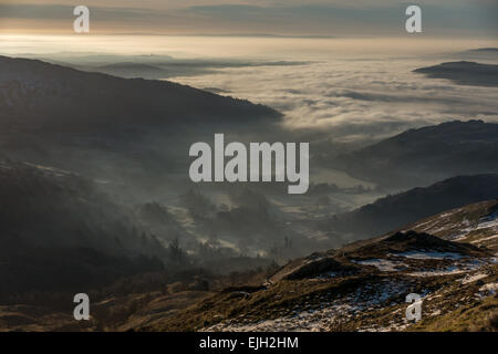 Dramatische ländliche Szene in einem nebelhaften Ambleside bei Sonnenaufgang mit Blick von der Seite der Fairfield Hufeisen, englischen Lake District, Großbritannien Stockfoto