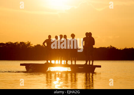 Gruppe von Menschen auf See Grande Cuyabeno Nationalpark in Ecuador gegen Sonnenuntergang Stockfoto