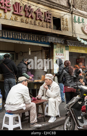 Die Menschen essen zu einem Kloß Restaurant in einem alten Wohnviertel in der Innenstadt von Shanghai, China Stockfoto