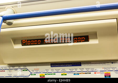 Dagegen Sie die Lücke Zeichen innen u-Bahn Wagen, London, England Stockfoto
