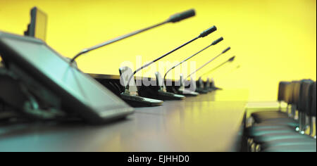 Konferenztisch, Mikrofone und Bürostühle, Closeup, gelb Stockfoto