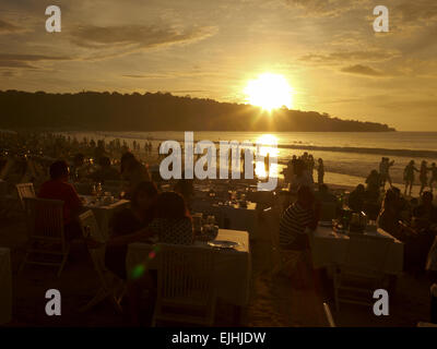 Frühes Abendessen am Strand bei Sonnenuntergang in Jimbaran, Bali, Indonesien Stockfoto