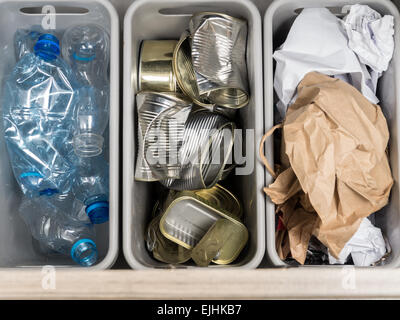 Drei Kunststoff Mülltonnen mit getrennten Hausmüll - PET-Flaschen, Papier und Metall Dosen von oben geschossen. Stockfoto