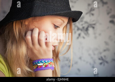 Profilbildnis schöne blonde Teenager-Mädchen in schwarzen Hut und GummiBracelets Webstuhl, getönten Foto Instagram-Stil-Effekt Stockfoto