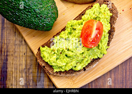 Sandwich mit Avocado Guacamole und Tomaten an Bord Stockfoto