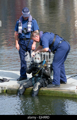 Kollegen aus der Metropolitan Police Service Marine Support Unit helfen einen Kollegen während einer Übung Tauchen vorbereiten. Stockfoto